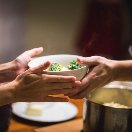 Hands passing bowl with food